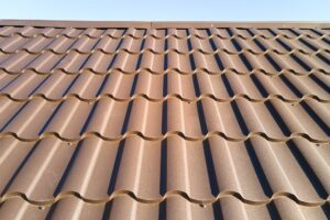 Closeup of house roof top covered with metallic shingles.
