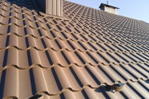 Closeup of house roof top covered with metallic shingles.