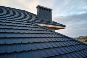 Closeup of house roof top covered with metallic shingles.Tiled covering of building.