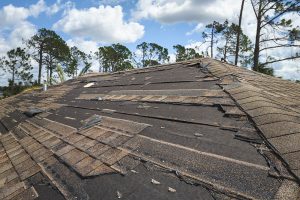 Damaged house roof with missing shingles 
