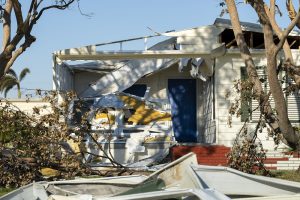 Property damage from strong hurricane winds. Mobile homes in Florida residential area with destroyed rooftops. Consequences of natural disaster.