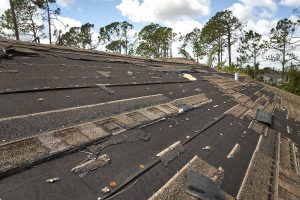 Damaged house roof with missing shingles 